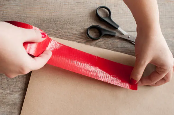 Scissors Cutting Christmas Ribbon While Wrapping A Present by