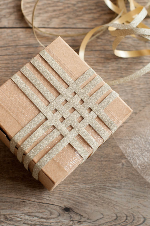 Gift wrapping. Wrapping paper, tape and gift box on a light wooden