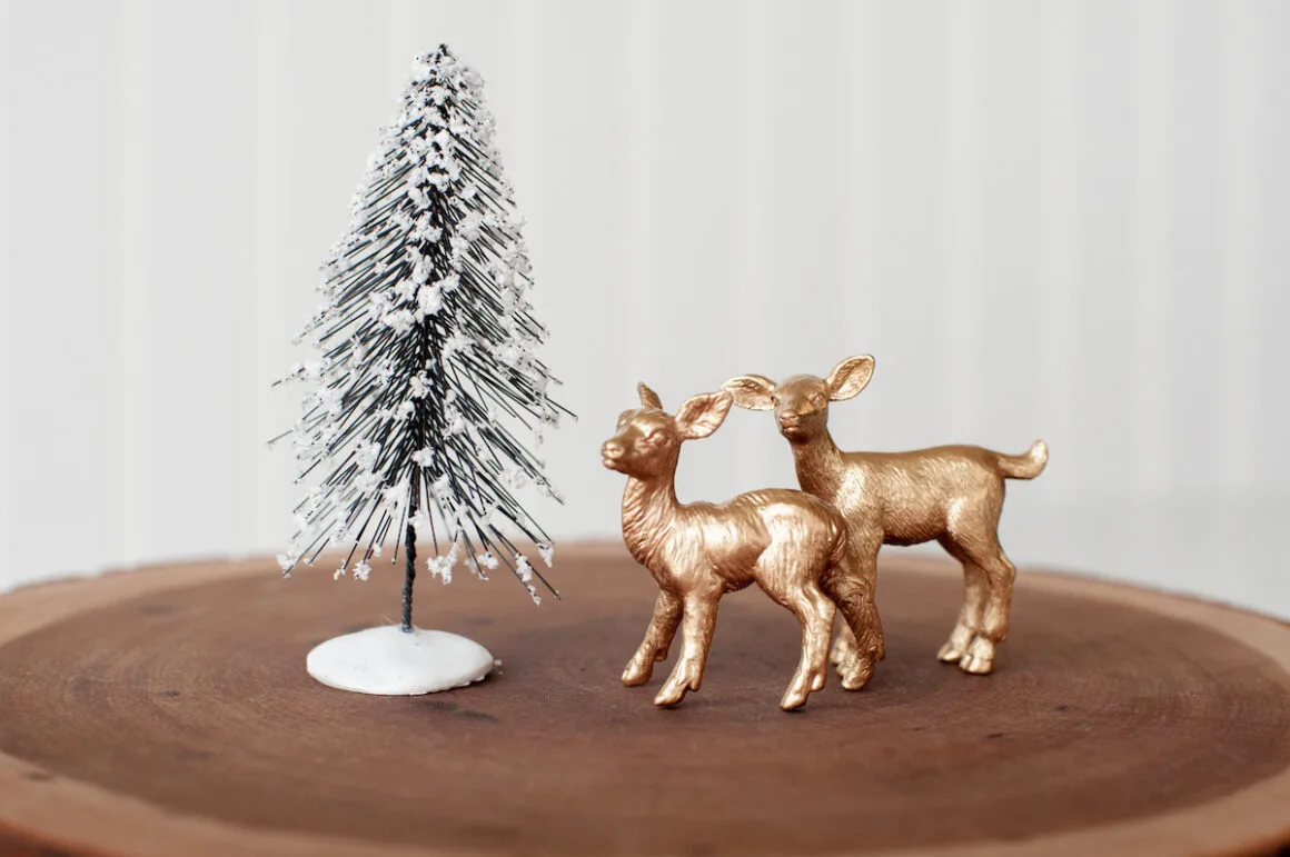 Gold deer figurines and a miniature pine tree on for making snow globes