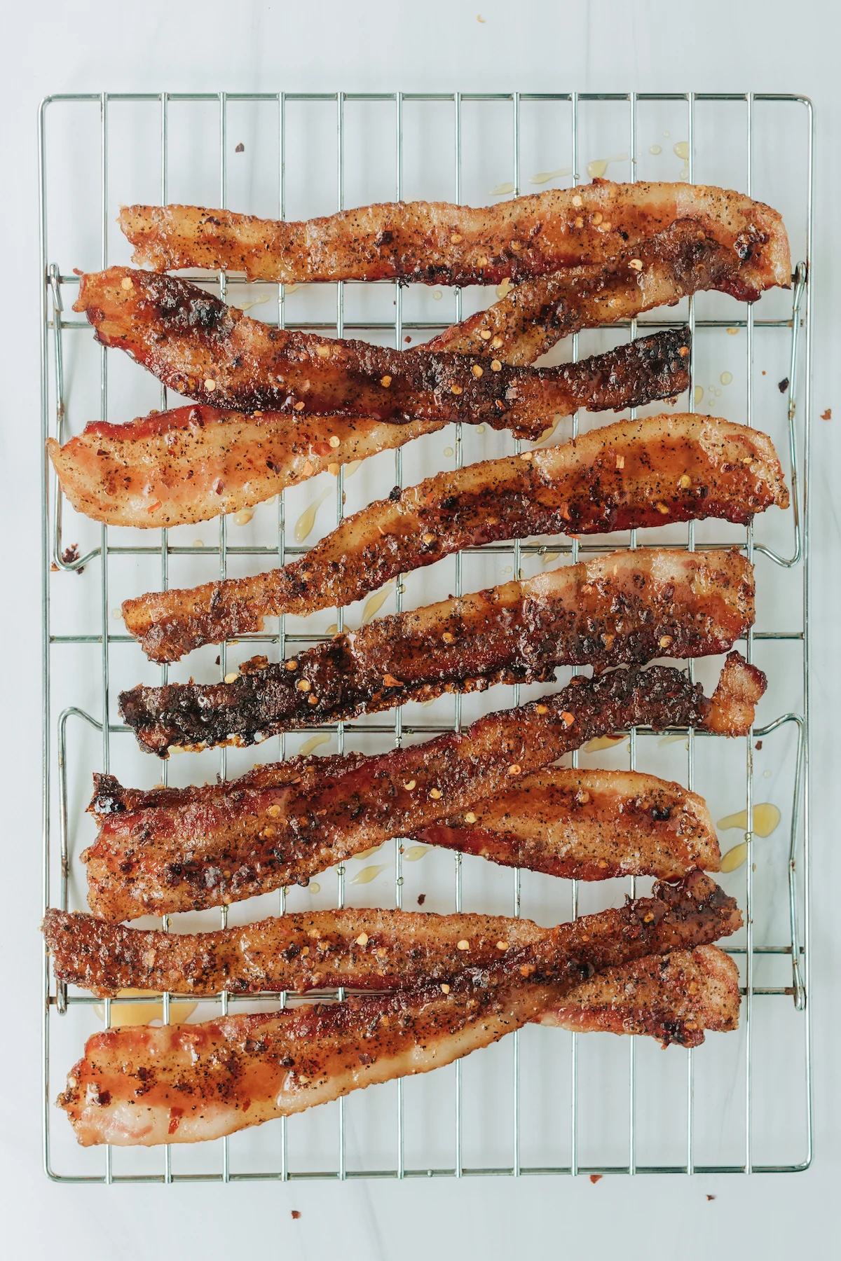 Million Dollar Bacon made with red pepper flakes and maple syrup on a baking rack.