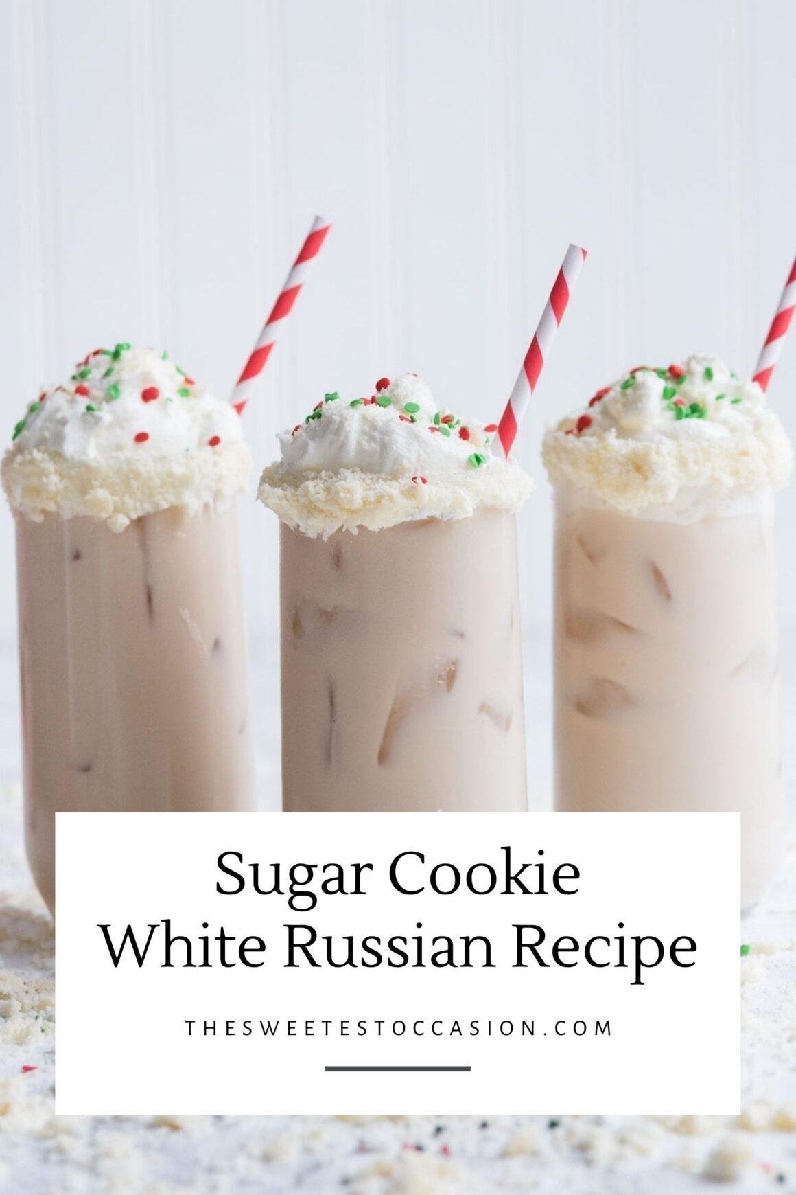 White Russian cocktail white whipped cream and sprinkles in a glass with a red and white striped straw