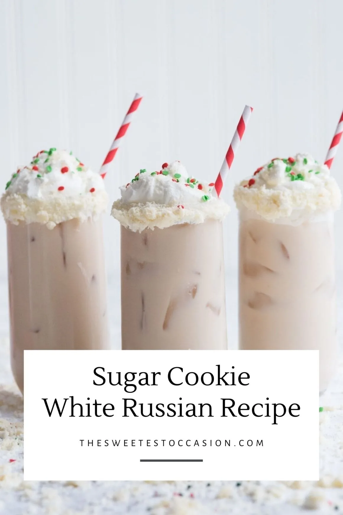 White Russian cocktail white whipped cream and sprinkles in a glass with a red and white striped straw